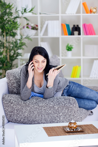 Foto: woman on the phone sitting on the sofa woman on the phone sitting on the sofa