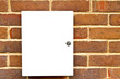 Locked white cupboard on a brick wall