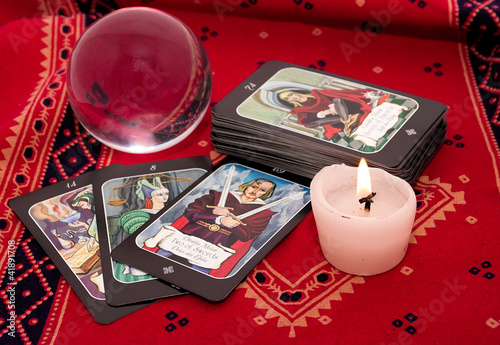 Photo: Tarot cards and crystal ball on red cloth Tarot cards and crystal ball on red cloth