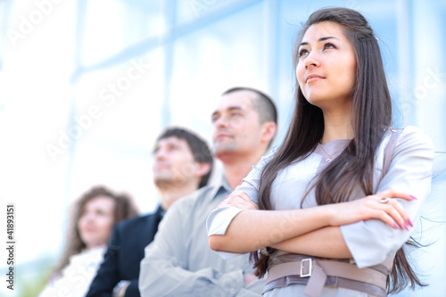 Photo: A business team with pretty leader in front looking at camera A business team with pretty leader in front looking at camera