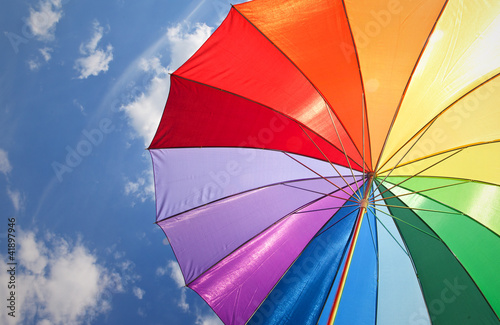Photo: Rainbow umbrella on sky background Rainbow umbrella on sky background