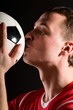 soccer player is kissing the ball