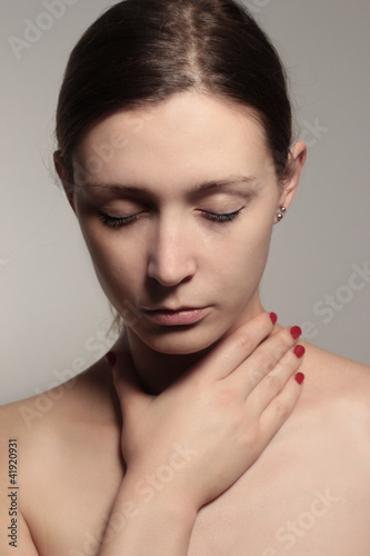 Photo: Woman holding throat Woman holding throat