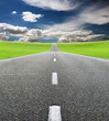 green field and road over blue sky green field and road over blue sky