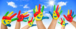 Many coloured hands of children in front of blue sky Many coloured hands of children in front of blue sky