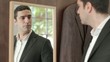 Adult man dressing up with suit and looking at mirror