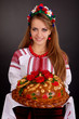 Young woman in ukrainian clothes, with garland and round loaf