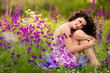Beautiful young woman in purple flowers outdoors