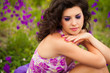 Beautiful young woman in purple flowers outdoors