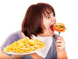 Overweight woman eating hamburger.