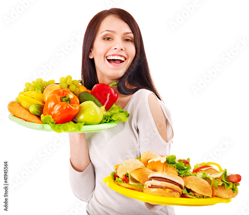 Photo: Woman choosing between fruit and hamburger. Woman choosing between fruit and hamburger.