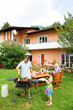 Photo: Family having a barbecue in the garden, eating Family having a barbecue in the garden, eating