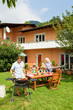 Photo: Family having a barbecue in the garden, eating Family having a barbecue in the garden, eating