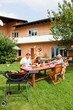 Photo: Family having a barbecue in the garden, eating Family having a barbecue in the garden, eating