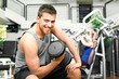 Young man lifting weights in the gym