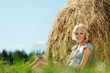 girl next to a stack of hay girl next to a stack of hay