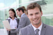 Handsome businessman standing in front of group of people