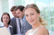 Beautiful businesswoman standing outside in front of team