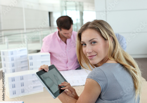 Photo: Beautiful woman in office using electronic tablet Beautiful woman in office using electronic tablet