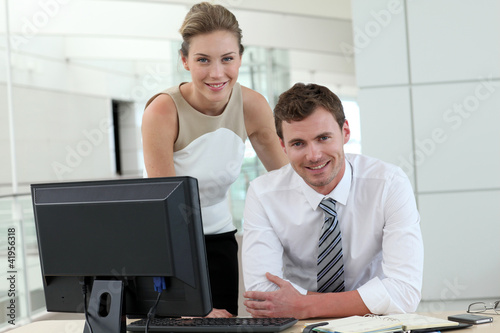 Photo: Business people meeting in office in front of desktop Business people meeting in office in front of desktop