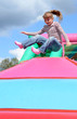 Happy child girl jumps on the inflatable playground