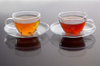 Transparent cup with green and black tea