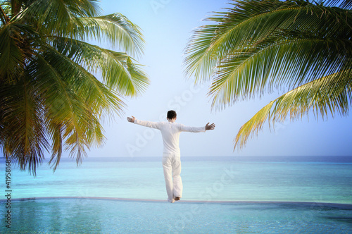 Photo: Man standing at Luxury tropical Infinity Pool (Maldives) Man standing at Luxury tropical Infinity Pool (Maldives)