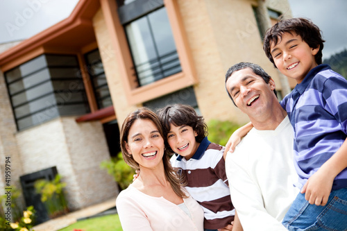 Foto: Beautiful family portrait smiling outside their new house Beautiful family portrait smiling outside their new house