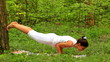 Young woman doing yoga exercise in green park