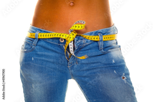 Photo: Schlanke Frau in Jeans mit Massband Schlanke Frau in Jeans mit Massband