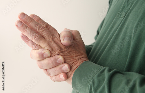 Photo: man tries to massage the numbness out of his hand man tries to massage the numbness out of his hand