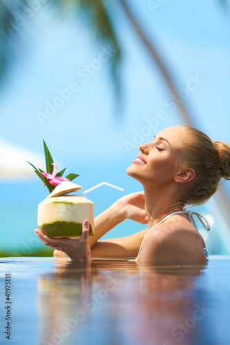 Photo: Woman relaxing in pool with a cocktail Woman relaxing in pool with a cocktail