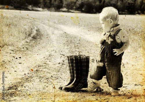 Photo: kid in harvested field. Photo in old image style. kid in harvested field. Photo in old image style.