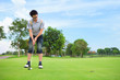 Young golfer putting on green