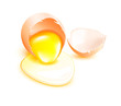 Brown broken egg with flowing yolk on white background Brown broken egg with flowing yolk on white background