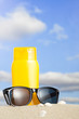 Tube with sun protection and sunglasses on beach