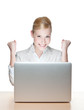 Smiling young businesswoman sitting at a desk with laptop