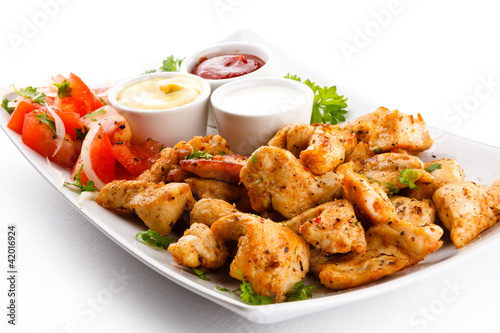Foto: Grilled meat and vegetables on white background Grilled meat and vegetables on white background