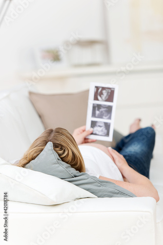 Foto: schwangere frau auf dem sofa mit ultraschall-fotos schwangere frau auf dem sofa mit ultraschall-fotos