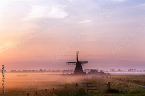 Photo: Dutch windmill in fog in the early morning Dutch windmill in fog in the early morning