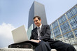 Businessman using his laptop in the city