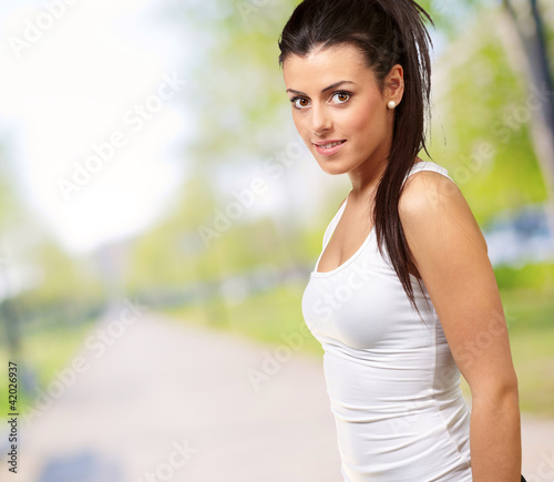 Photo: portrait of a pretty young woman at park portrait of a pretty young woman at park