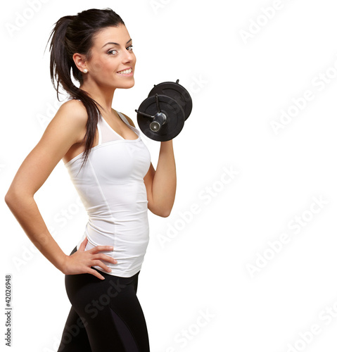 Photo: portrait of a young pretty woman holding weights and doing fitne portrait of a young pretty woman holding weights and doing fitne