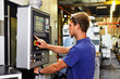 skilled worker controlling a digitally programmed machine tool