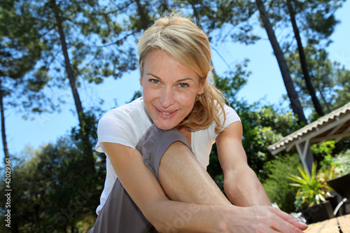 Foto: Middle-aged woman doing fitness exercises outside Middle-aged woman doing fitness exercises outside