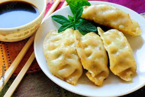 Photo: A Plate of Fried Chinese Gyoza, Soy Sauce and White Chopsticks A Plate of Fried Chinese Gyoza, Soy Sauce and White Chopsticks