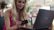 Woman doing online shopping in cafe, steadicam shot