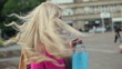 Happy woman with shoping bags in city, slow motion