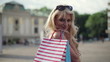 Happy woman with shoping bags in the city, steadicam shot
