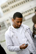 Afro-American man sending text message on phone